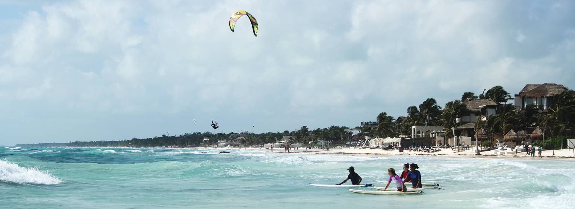 Group of beginners enters the ocean at our bay in Tulum for first surf lesson.